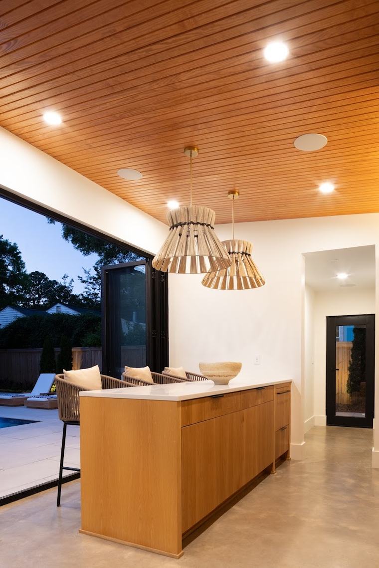 Ceiling-integrated speakers and pendant lighting over a kitchen island